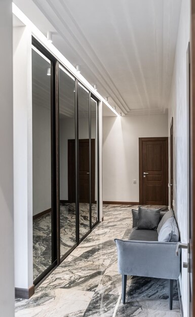 design-corridor-has-light-walls-marble-floor-gray-sofa-large-wardrobe-with-mirrors_716147-4876